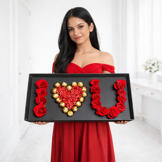 Woman in a red dress holding a decorative box with red roses and a heart design.