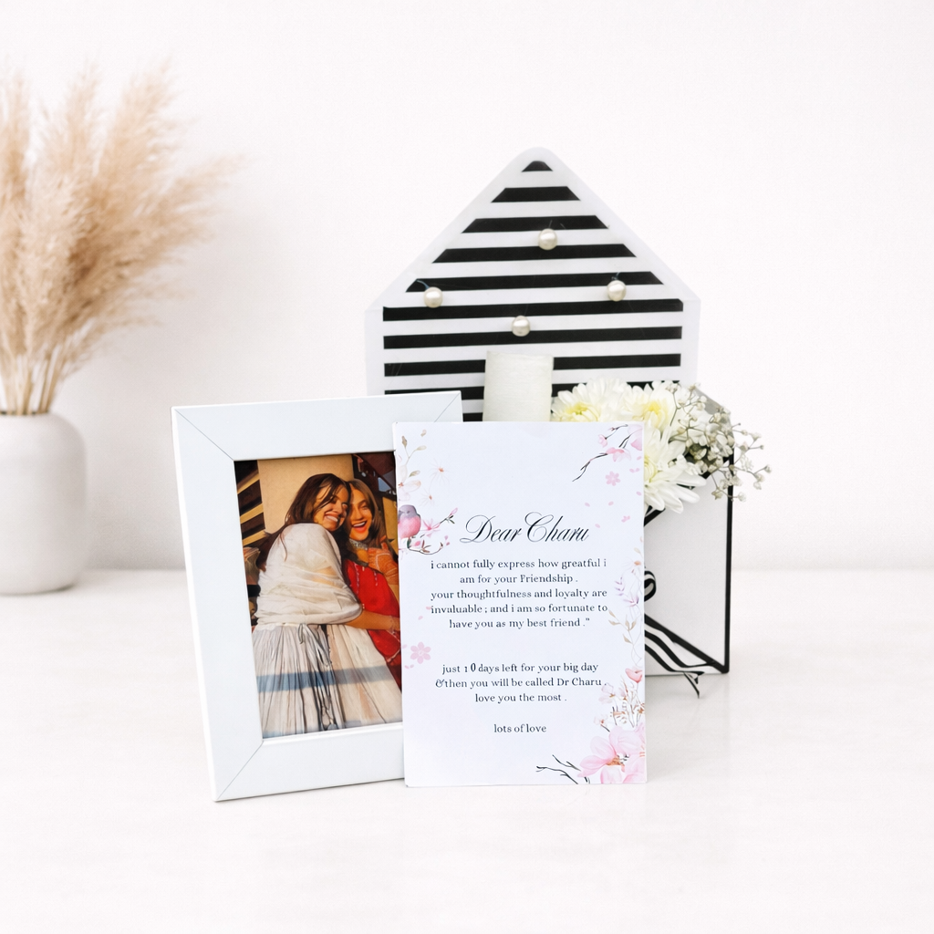 Black and white striped photo frame with a white frame and a card on a white surface.