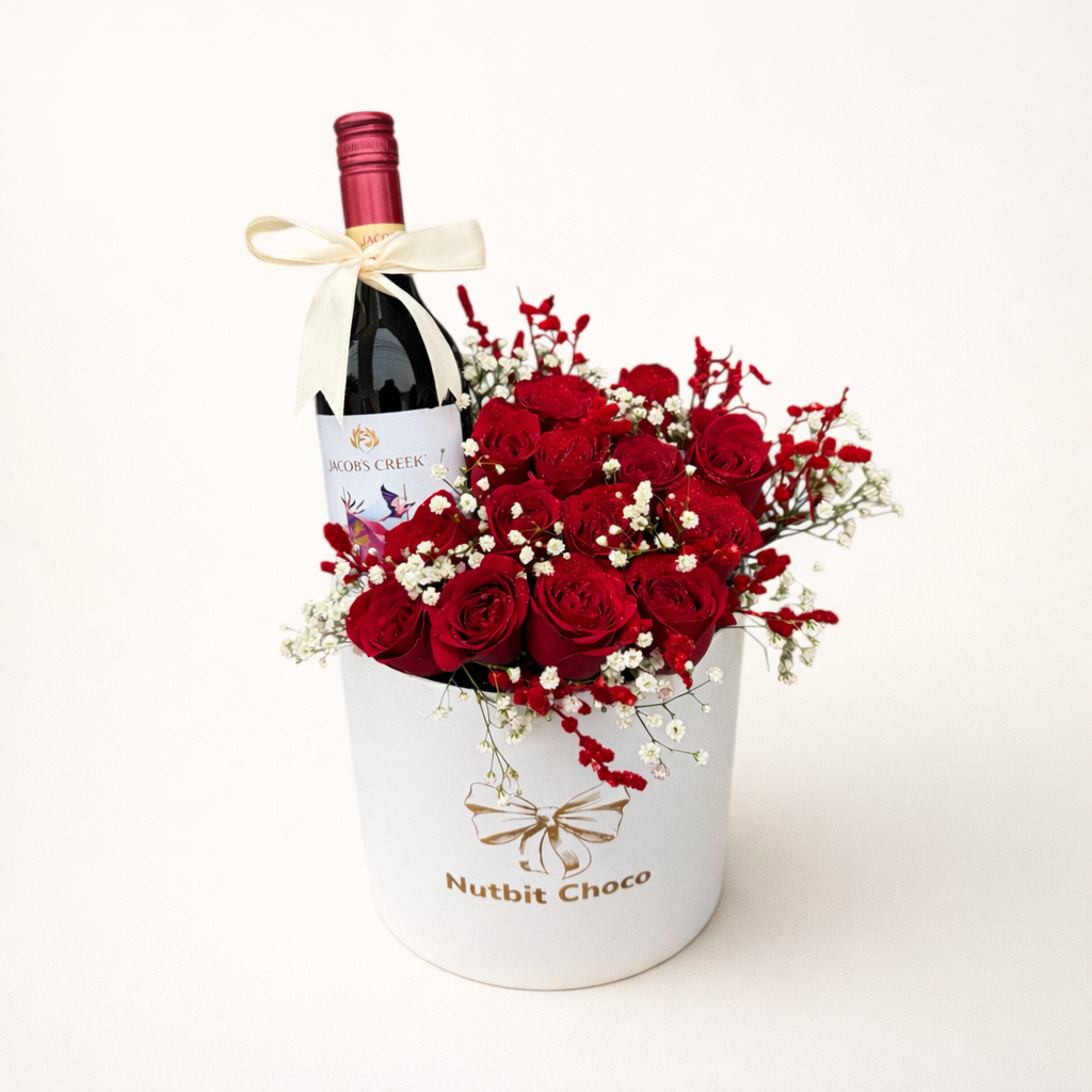 Bottle of wine and bouquet of red roses in a white container on a white background