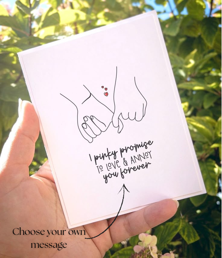 Card with illustration of hands holding a heart and text, held by a hand against a green leafy background.