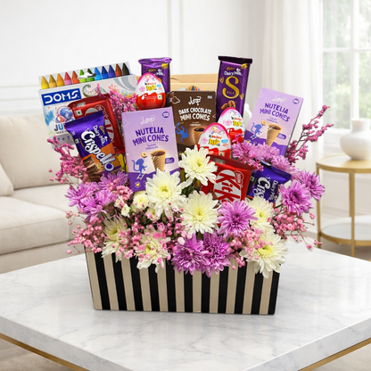 Gift basket with flowers and snacks on a table in a living room setting