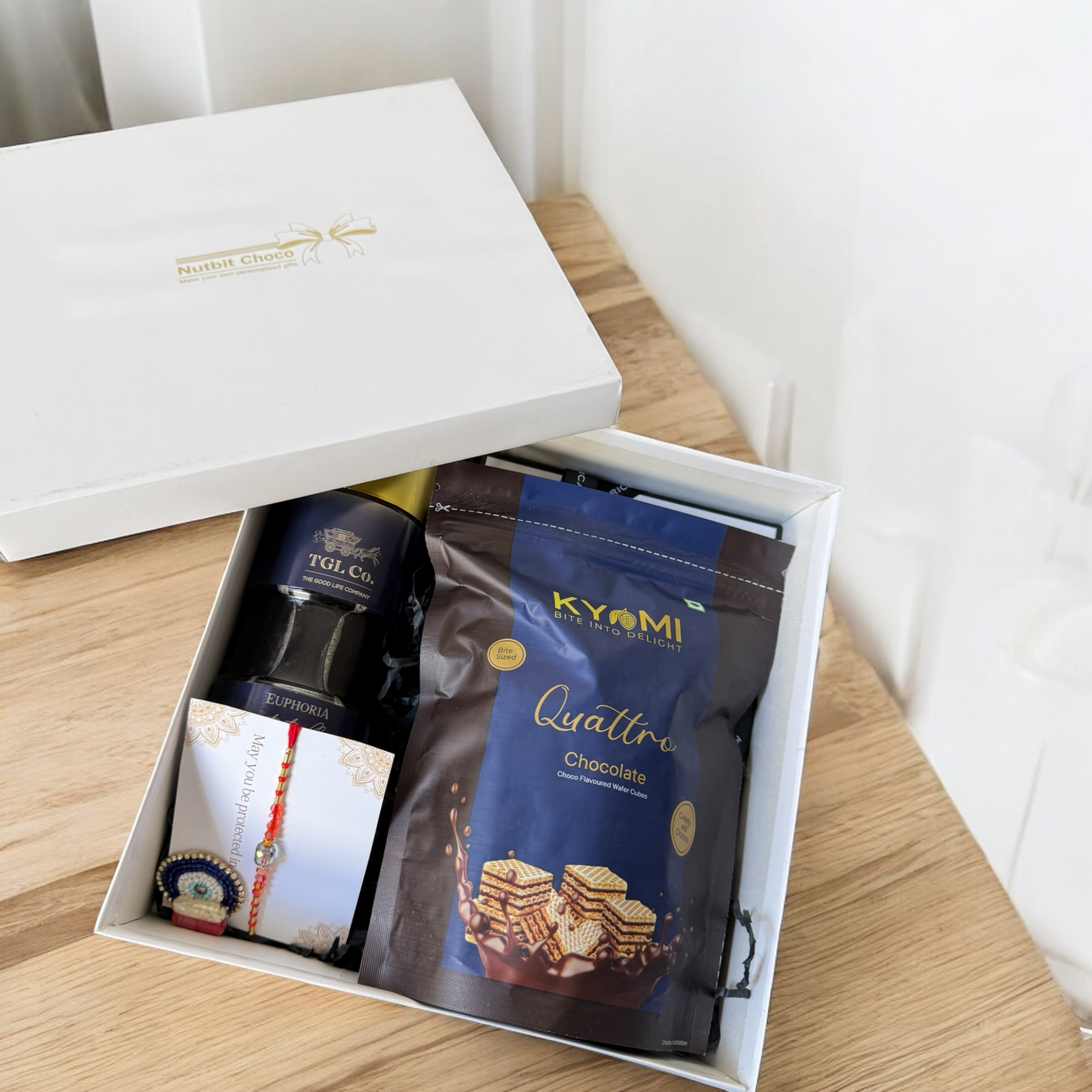 Gift box withKYMI chocolate and other items on a wooden surface