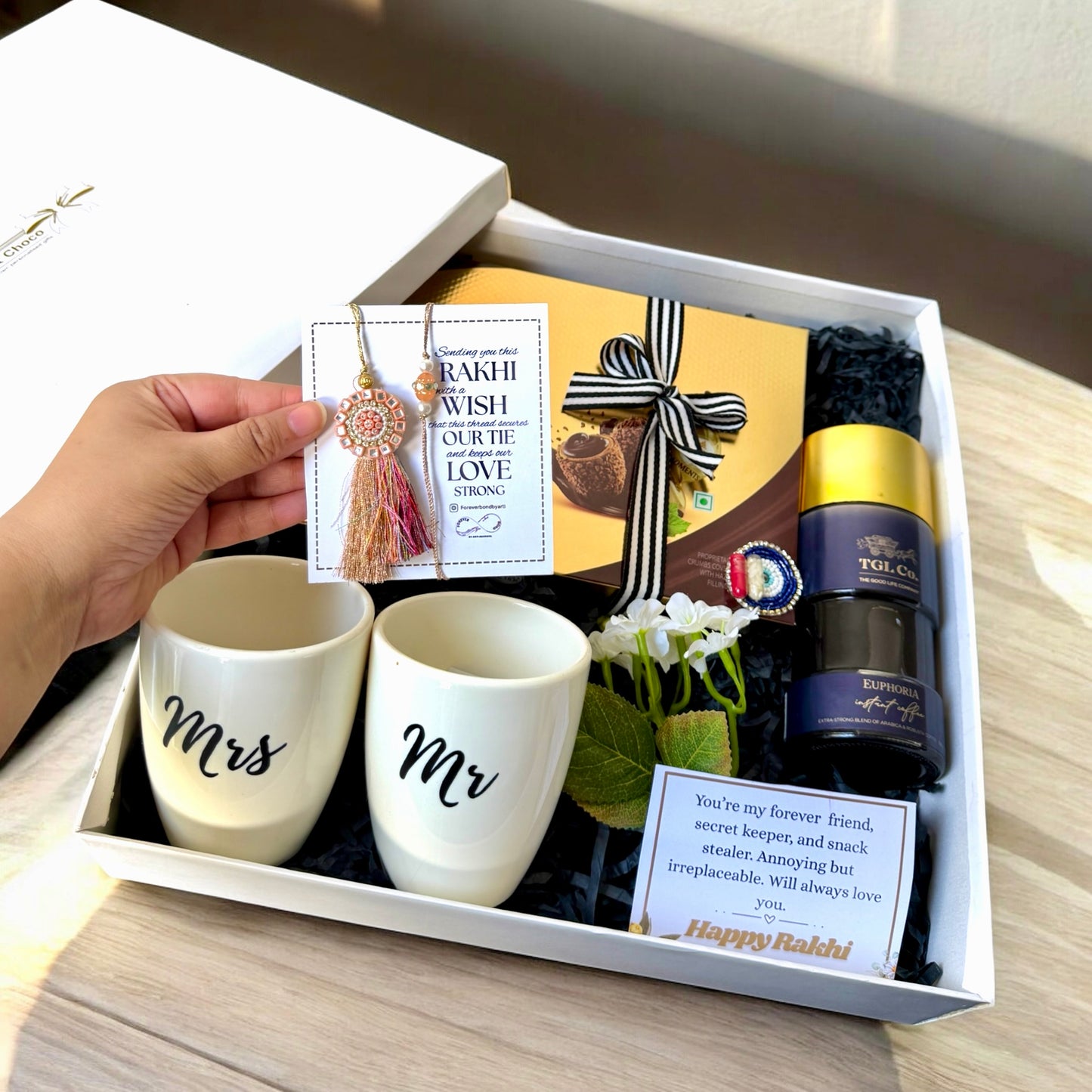 Gift set with 'Mr' and 'Mrs' mugs, a bottle, and decorative items in a box.