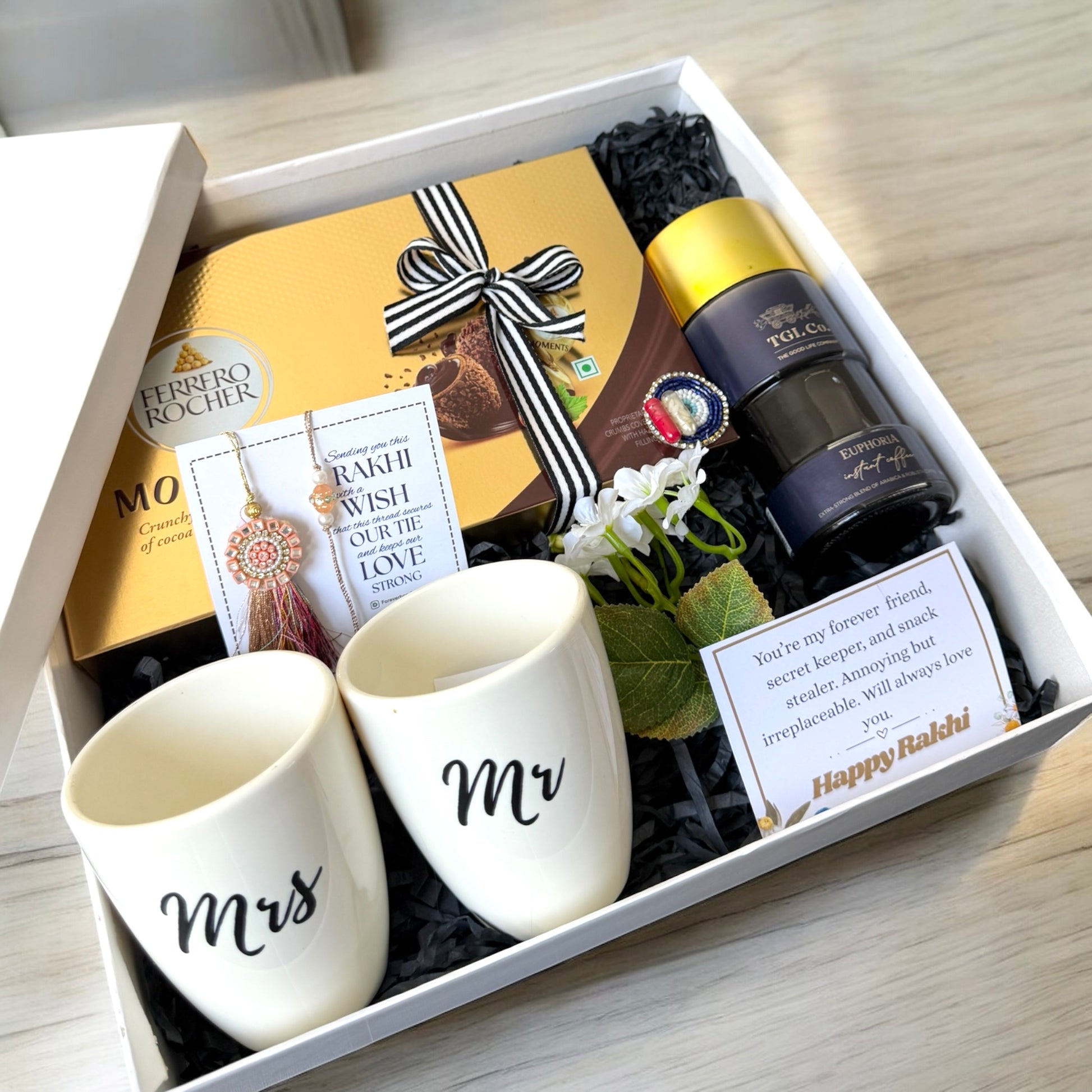 Gift set with 'Mr' and 'Mrs' mugs, chocolate, and a bottle of wine in a box.