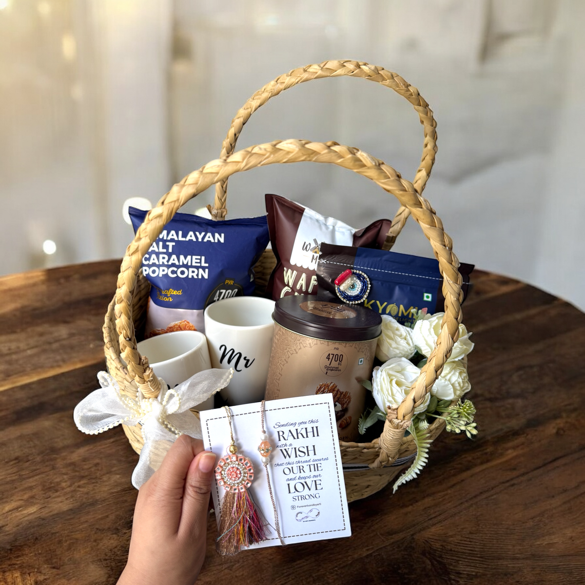 Gift basket with coffee, snacks, and decorative items on a wooden table.