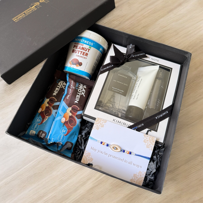 Gift box with snacks, peanut butter, and a card on a wooden surface