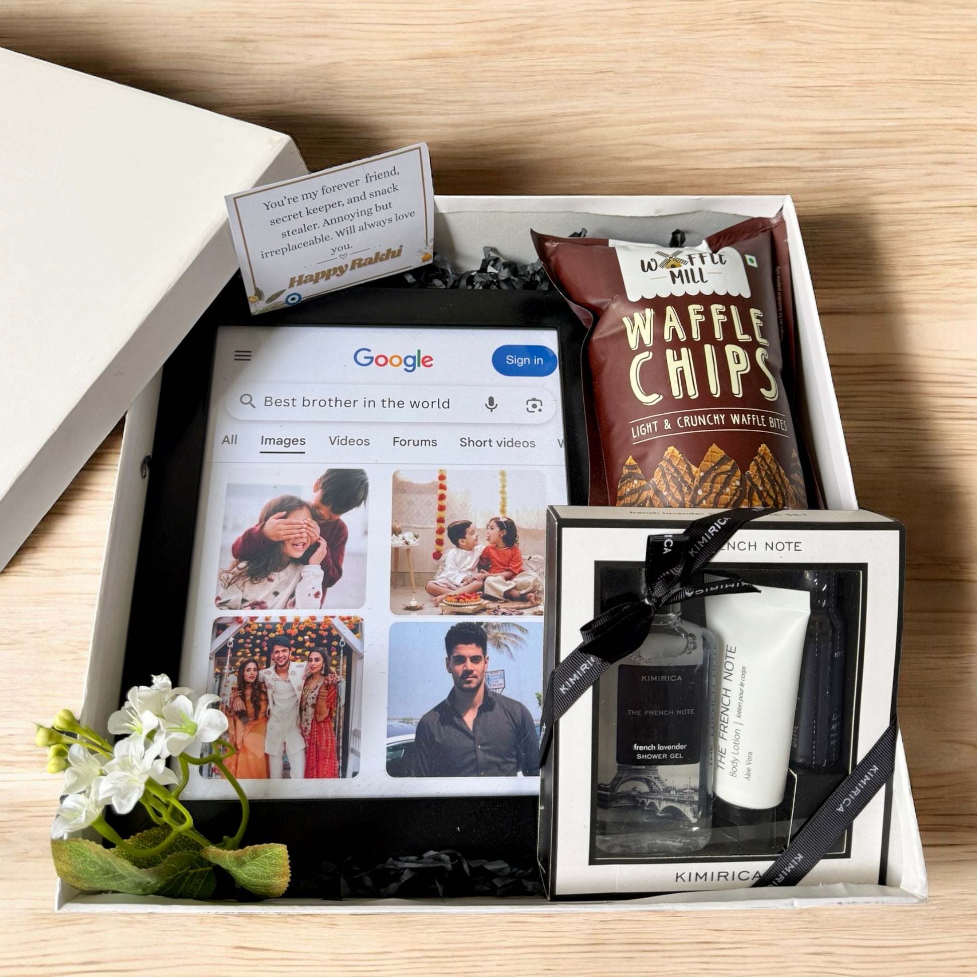 Gift box with photo album, waffle chips, and skincare products on a wooden surface