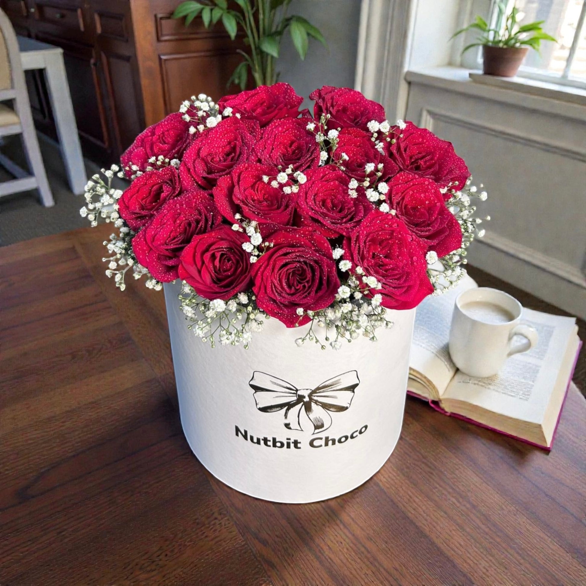 Bouquet of red roses in a white box with 'Nutbit Choco' branding on a wooden table.