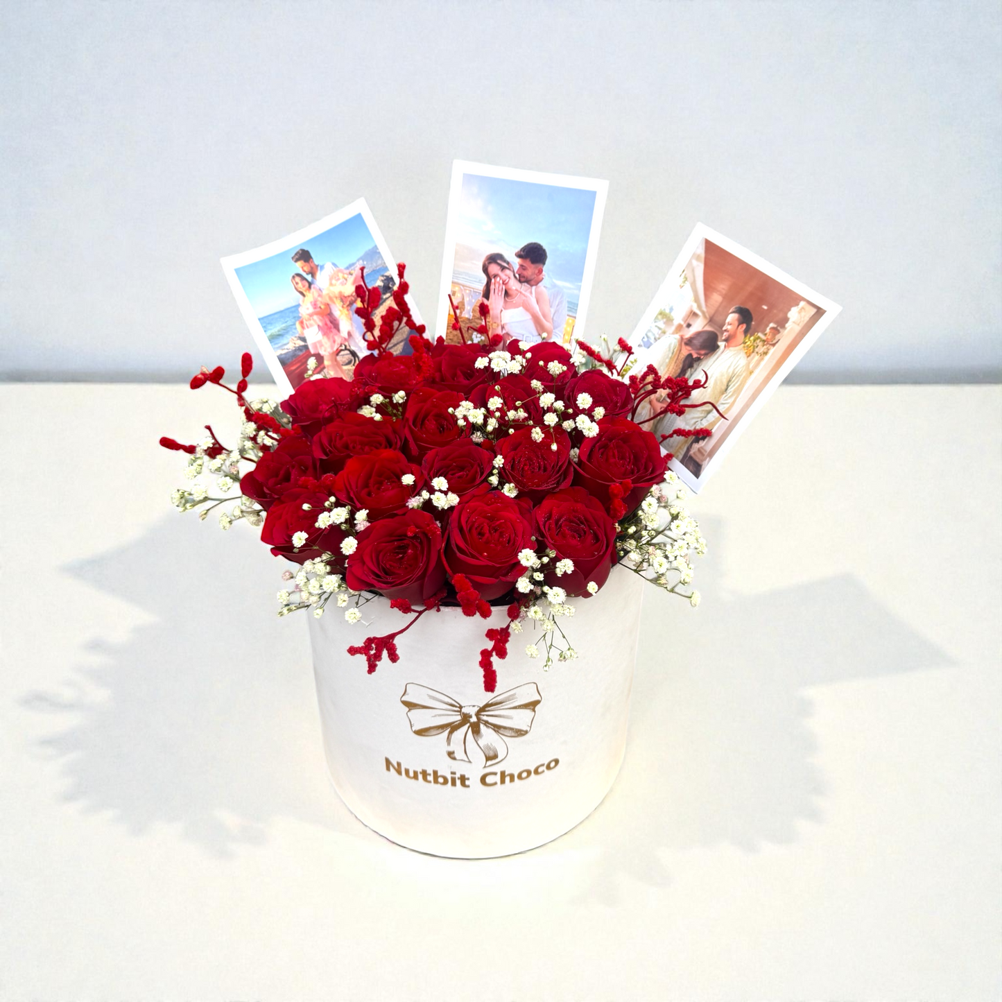 Bouquet of red roses in a white box with 'Nutbit Choco' branding, surrounded by photos on a light background.